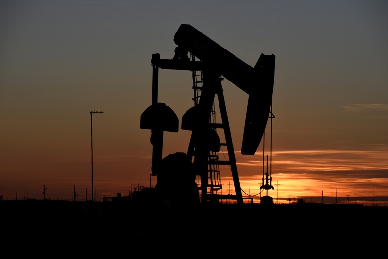 A pump jack operates at sunset in an oil field in Midland