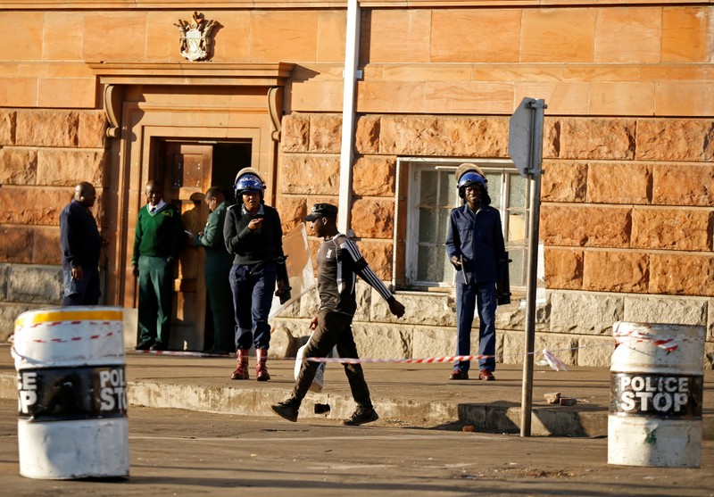 Riot police officers keep watch outside the Tredgold Building Magistrate court in Bulawayo