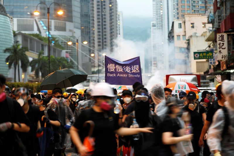 FILE PHOTO : Anti-extradition bill protesters run as riot police fire tear gas during a protest in Hong Kong
