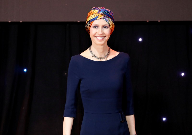 FILE PHOTO: Asma al-Assad, wife of Syrian President Bashar al-Assad, reacts during the graduation ceremony of professors from Damascus University, who will work at the Syrian Organisation for Persons with Disabilities, in Damascus