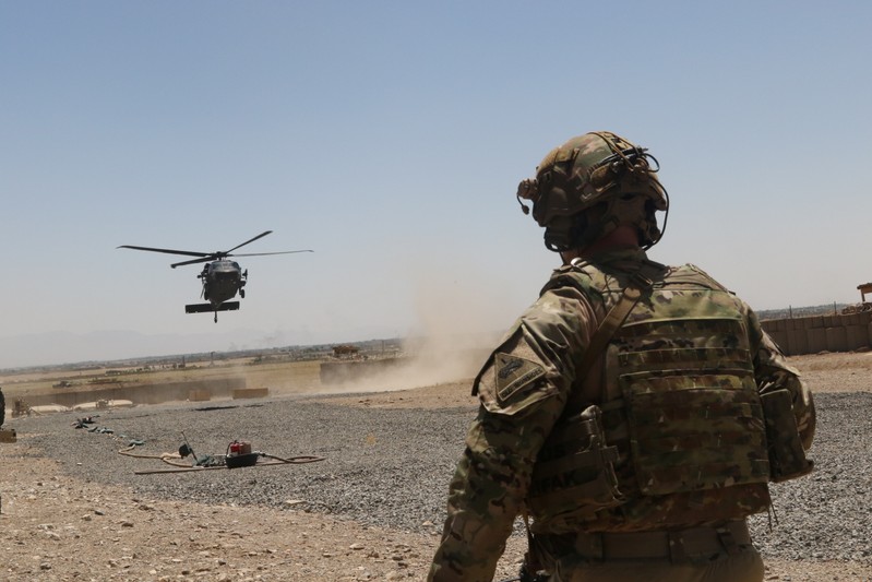 A U.S. soldier watches as a UH-60 Blackhawk Helicopter prepares to land during an advise and assistance mission in southeastern Afghanistan