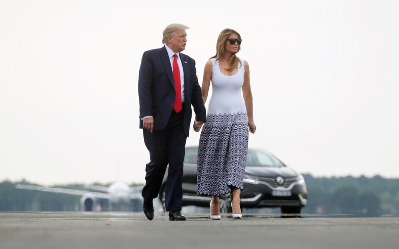 U.S. President Donald Trump and U.S. first lady Melania Trump walk on a tarmac as they return from the G7 summit, in Bordeaux