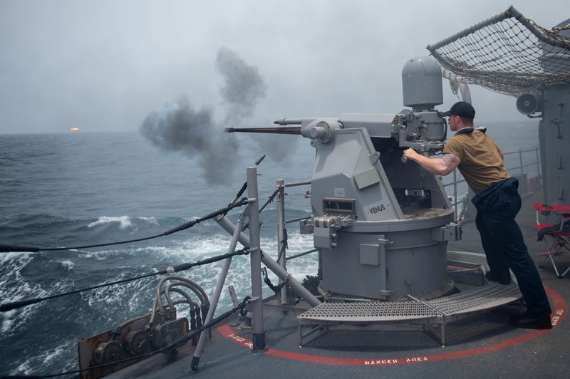 FILE PHOTO: A gunner fires a Mark 38 25 mm machine gun system during a live-fire exercise aboard the guided-missile cruiser USS Leyte Gulf (CG 55) in the Gulf