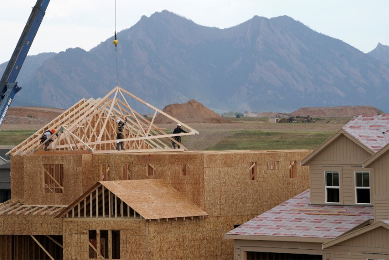 Workers install roof trusses onto a new house in Arvada