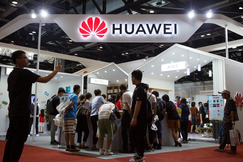 FILE PHOTO: People look at products at the Huawei stall at the International Consumer Electronics Expo in Beijing