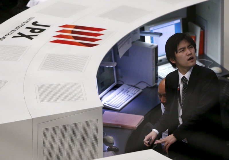 FILE PHOTO: Employees of the Tokyo Stock Exchange (TSE) work at the bourse in Tokyo,
