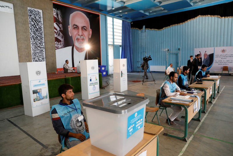 Election workers wait for Afghan presidential candidate Ashraf Ghani, to vote in the presidential election in Kabul, Afghanistan