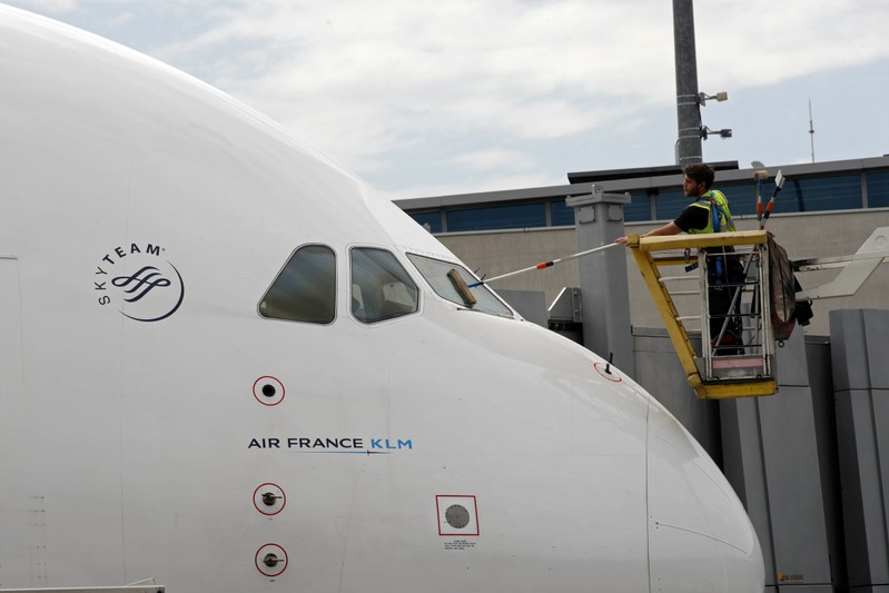 FILE PHOTO: A worker cleans the windshield of an Air France-KLM plane at the Paris Charles de Gaulle Airport in Roissy