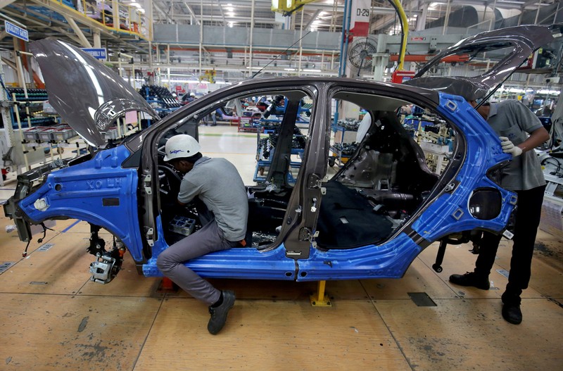 FILE PHOTO: Workers on a car assembly line at the Tata Motors plant in Sanand, on the outskirts of Ahmedabad