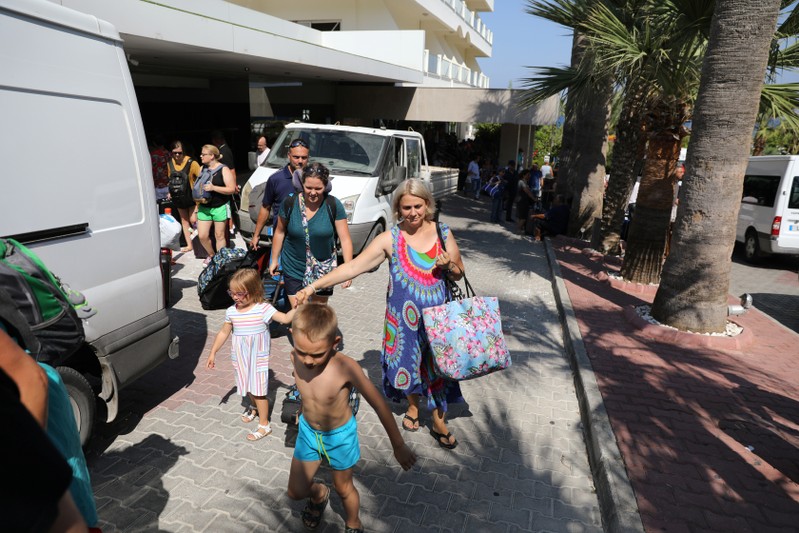 Guests walk outside the main entrance of a hotel following a blast in a military ammunition depot near the town of Kyrenia in nothern Cyprus