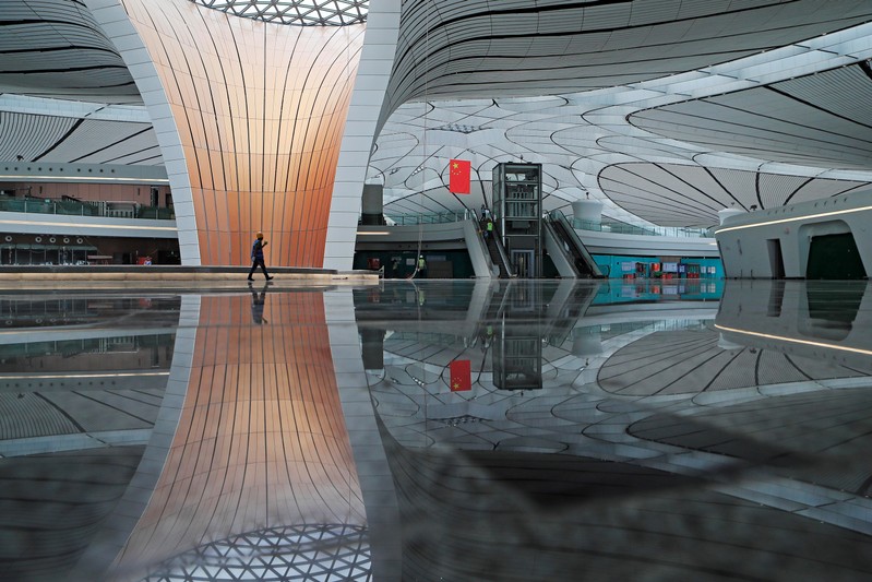 FILE PHOTO: Worker walks inside the terminal hall of the Beijing Daxing International Airport under construction in Daxing district, Beijing