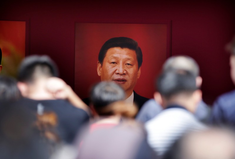 FILE PHOTO: Visitors are seen in front of a picture of Chinese President Xi Jinping during an exhibition on China's achievements marking the 70th anniversary of its founding at the Beijing Exhibition Center
