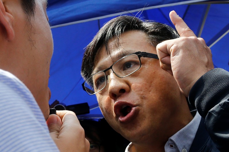 Pro-Beijing lawmaker Junius Ho argues with a pro-democracy lawmaker before demonstration of a water cannon equipped vehicle at the compound of the Police Tactical Unit in Hong Kong