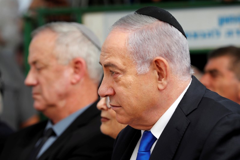 FILE PHOTO: Israeli Prime Minister Benjamin Netanyahu looks on as he sits next to Benny Gantz, leader of Blue and White party, during a memorial ceremony for late Israeli President Shimon Peres, at Mount Herzl in Jerusalem