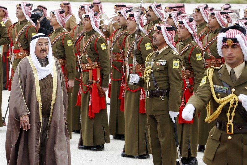 Kuwait's Emir Sheikh Sabah al-Ahmad al-Sabah reviews Bedouin honour guards upon his arrival at Amman airport