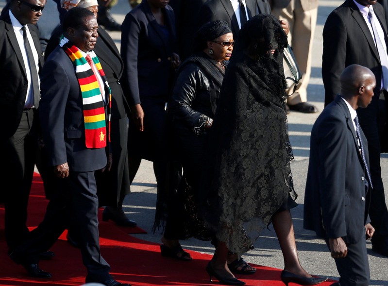 Zimbabwean President Emmerson Mnangagwa leaves with Grace Mugabe, after receiving the body of her husband, former Zimbabwean President Robert Mugabe in Harare