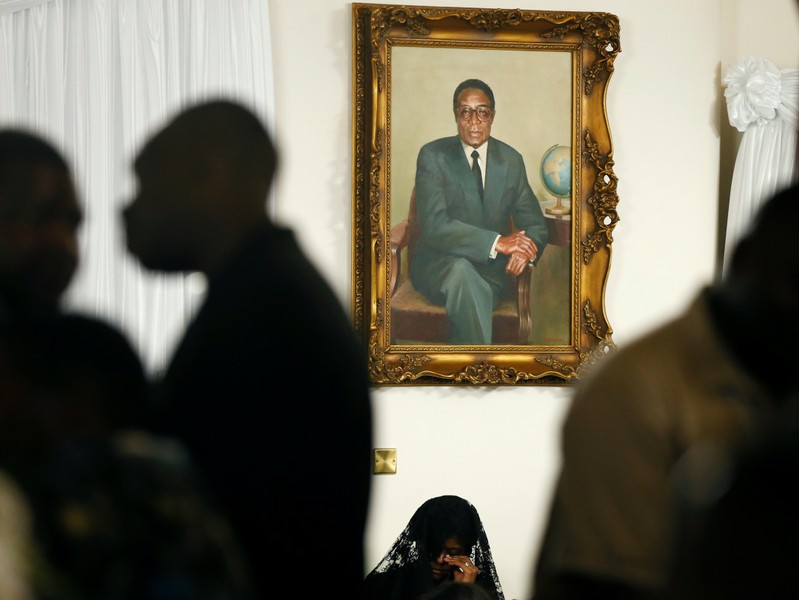 Grace Mugabe sits below a portrait of her late husband, former Zimbabwean President Robert Mugabe