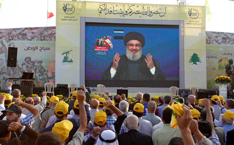 Lebanon's Hezbollah leader Sayyed Hassan Nasrallah gestures as he addresses his supporters via a screen during a rally marking the anniversary of the defeat of militants near the Lebanese-Syrian border, in al-Ain village