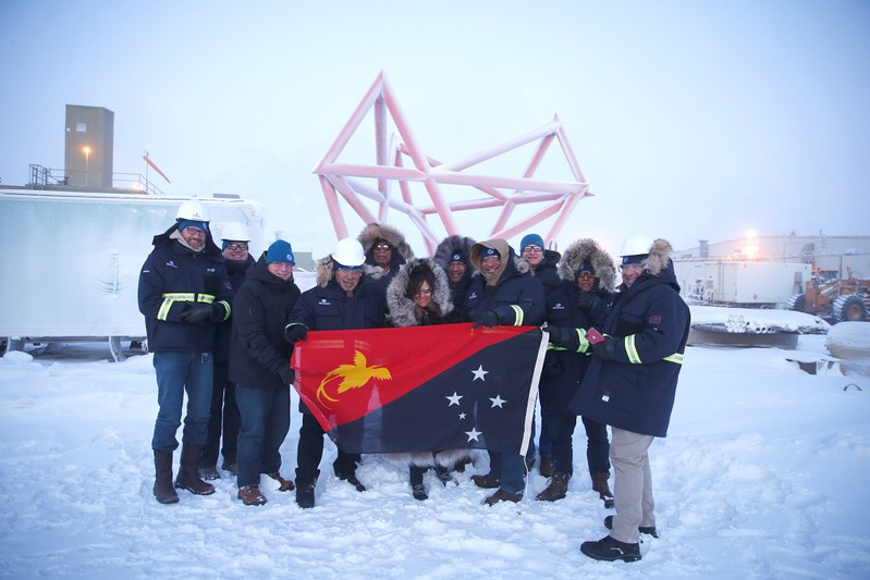 Participants pose for a photo with a Papua New Guinea flag during a stakeholder field trip to Oil Search facilities in Prudhoe Bay