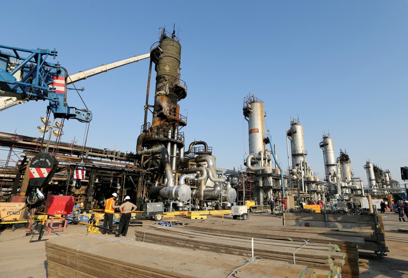 FILE PHOTO: Workers are seen at the damaged site of Saudi Aramco oil facility in Abqaiq