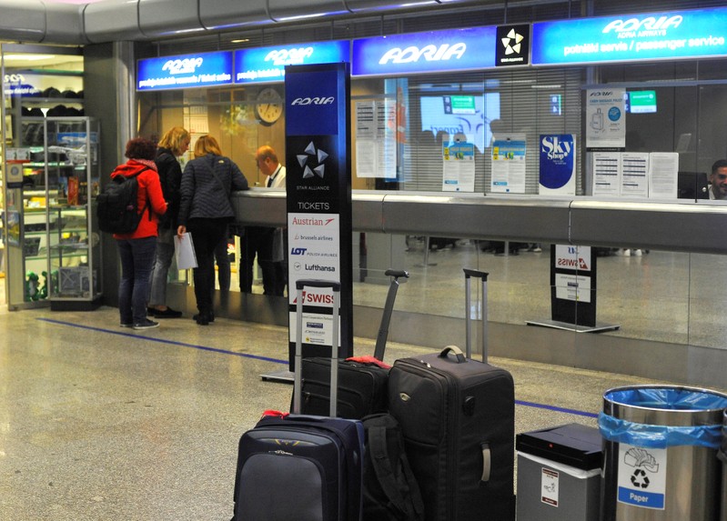 Passengers stand at an information desk at the airport after Adria Airways suspended all flights in Brnik