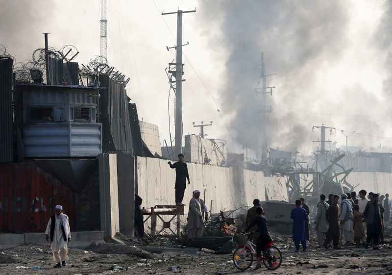 FILE PHOTO: Angry Afghan protesters burn tires and shout slogans at the site of a blast in Kabul, Afghanistan