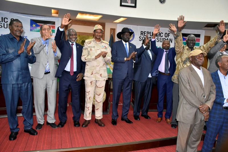 Sudanese officials, rebels and diplomats react after signing the initial agreement on a roadmap for peace talks in Juba