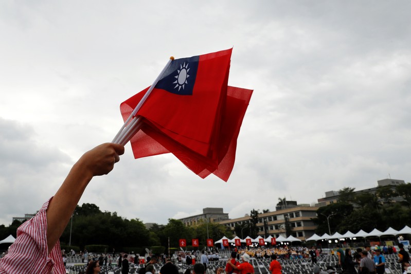 An audience waves Taiwanese flags during the National Day celebrations in Taipei