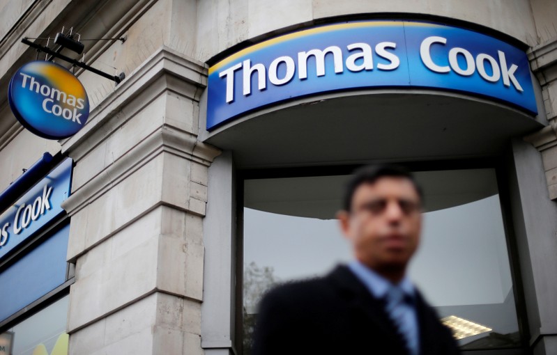 FILE PHOTO: A pedestrian walks past a Thomas Cook shop in central London