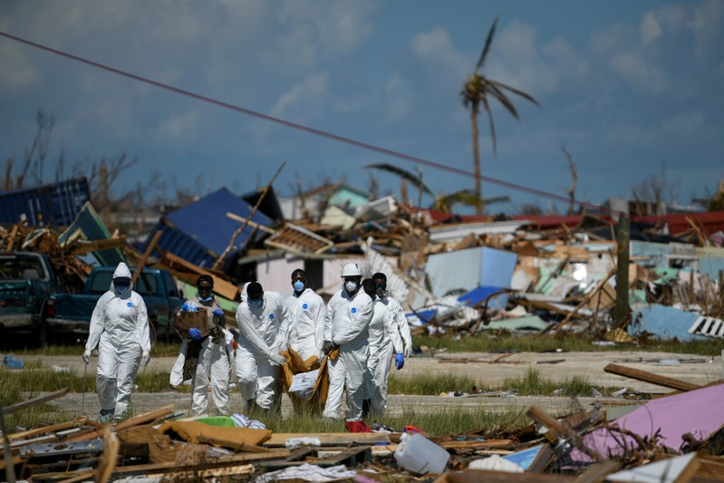 FILE PHOTO: Personnel from the Royal Bahamas Police Force remove a body recovered in a destroyed neighbourhood in the wake of Hurricane Dorian in Marsh Harbour