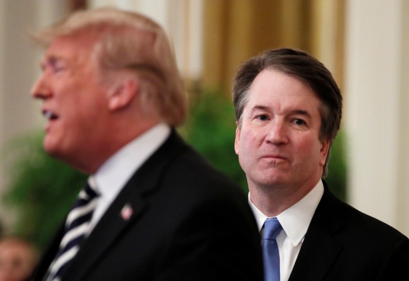 FILE PHOTO: U.S. President Donald Trump speaks next to U.S. Supreme Court Associate Justice Brett Kavanaugh as they participate in a ceremonial public swearing-in in the East Room of the White House in Washington