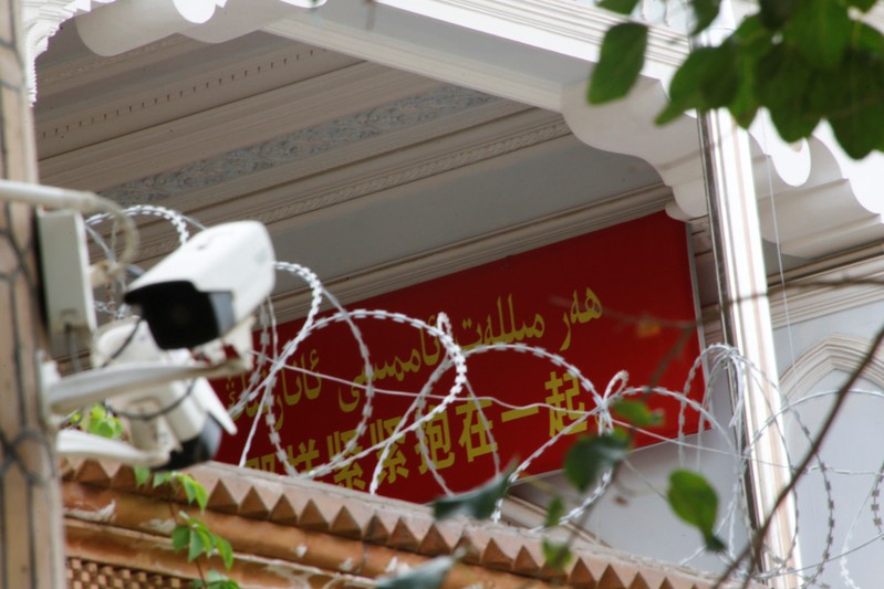 A propaganda banner and a security camera are placed on the walls of a mosque in the Old City in Kashgar