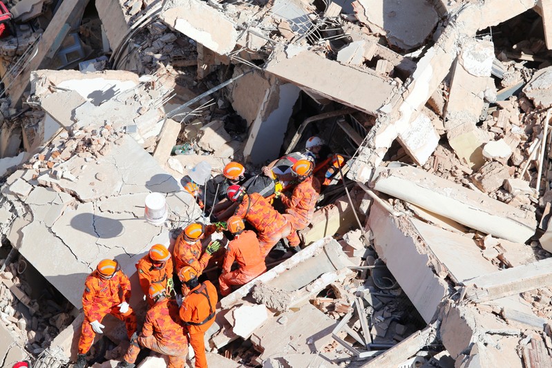 Rescue workers carry a victim after a seven-story residential building collapsed in Fortaleza