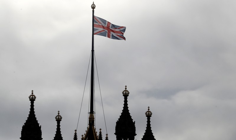 A Union Jack flag flutters atop Victoria Tower, in London