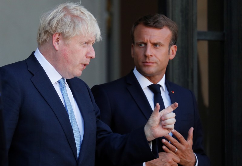FILE PHOTO: French President Emmanuel Macron accompanies British Prime Minister Boris Johnson after a meeting on Brexit at the Elysee Palace in Paris
