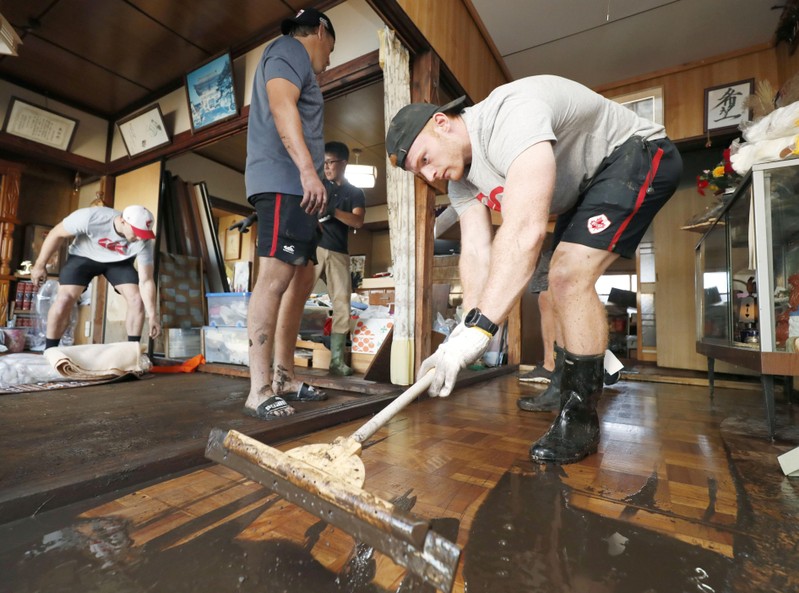 Canada's rugby player Nelson helps remove mud inside a house at a flooded area, caused by Typhoon Hagibis in Kamaishi