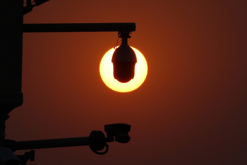 Rising sun is seen behind surveillance cameras before a military parade marking the 70th founding anniversary of People's Republic of China