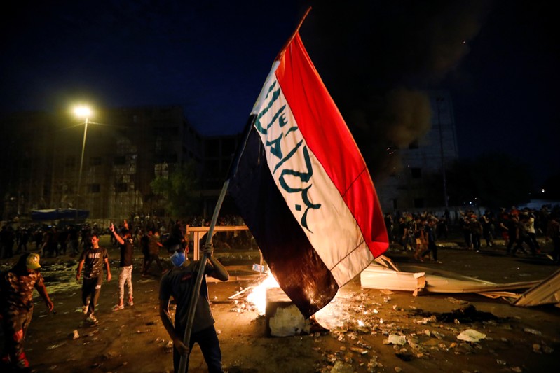 Demonstrators gather at a protest during a curfew, two days after the nationwide anti-government protests turned violent, in Baghdad