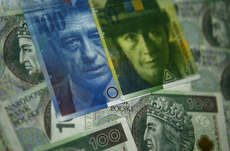 FILE PHOTO: Various Swiss Franc and Polish Zloty notes lay on a table in this picture illustration in Warsaw