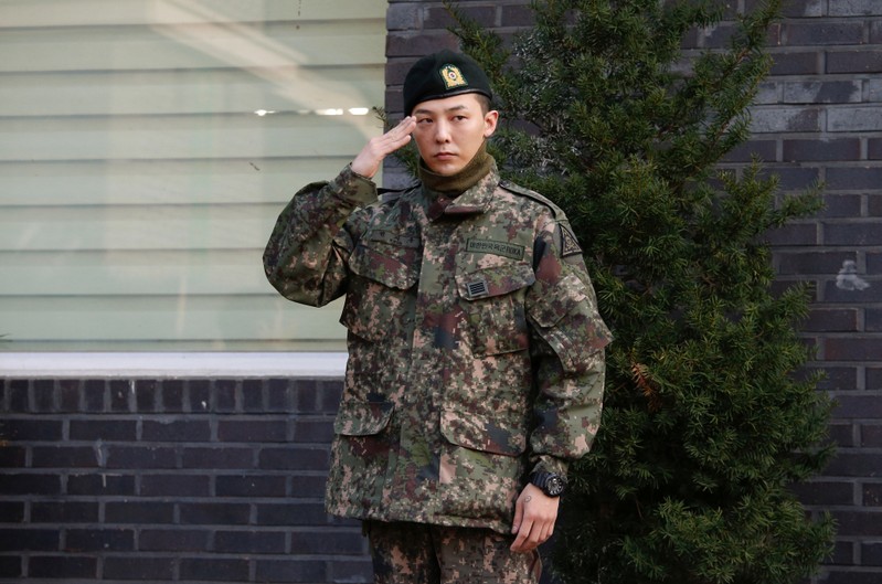 Leader of South Korean K-pop boyband BIGBANG G-Dragon poses for photographs after being discharged from army in Yongin