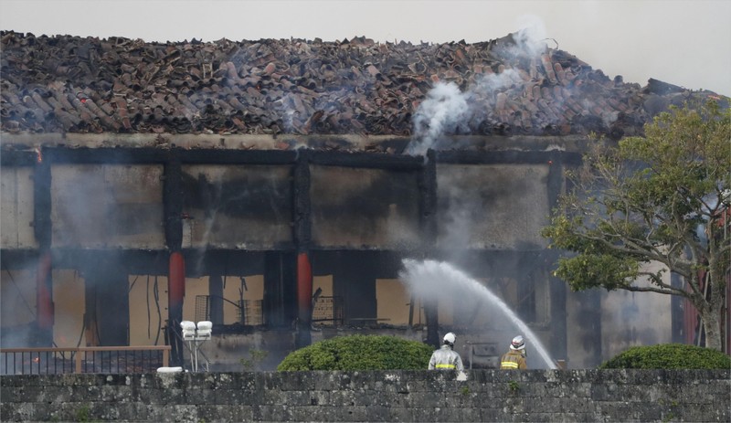 Firefighters try to extinguish a fire at Shuri Castle, listed as a World Heritage site, in Naha on the southern island of Okinawa, Japan