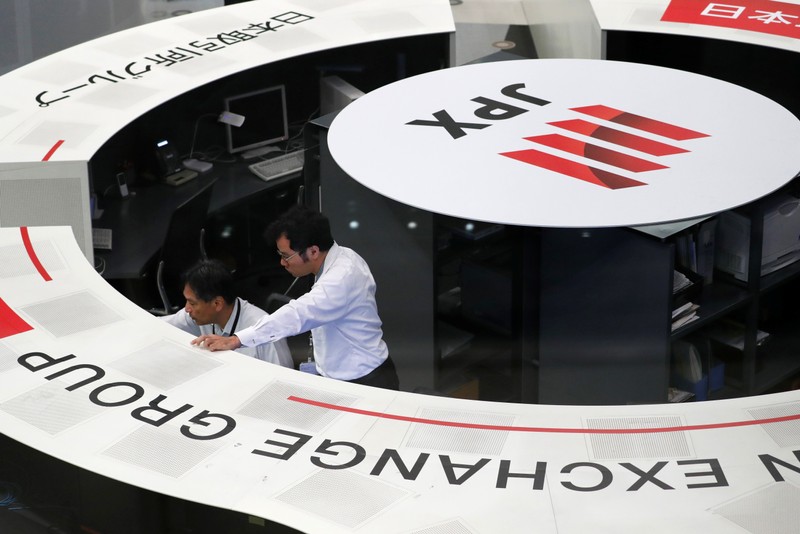 FILE PHOTO: Employees of the Tokyo Stock Exchange work at the bourse in Tokyo
