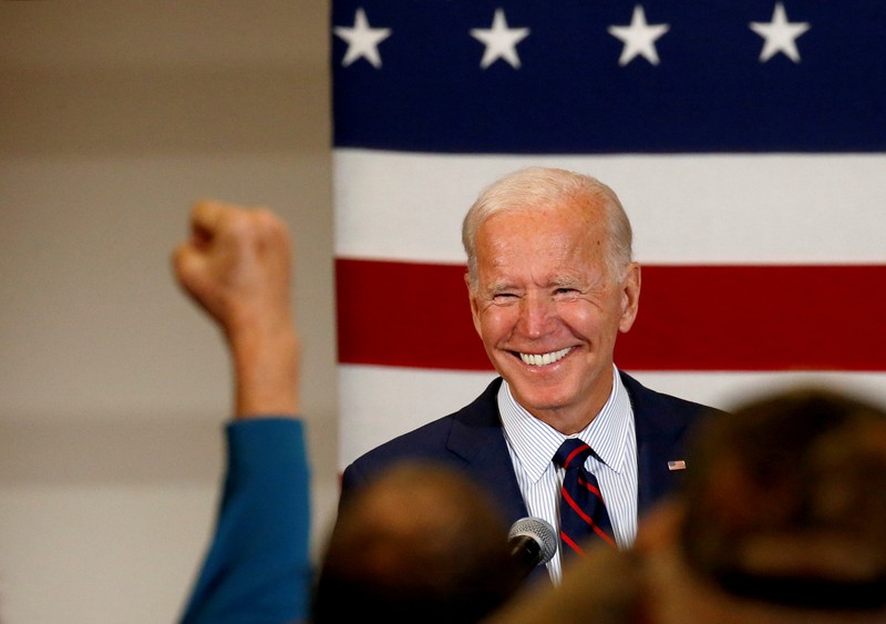 FILE PHOTO: Democratic 2020 U.S. presidential candidate and former Vice President Joe Biden smiles as a supporter pumps a fist at a campaign town hall meeting in Manchester