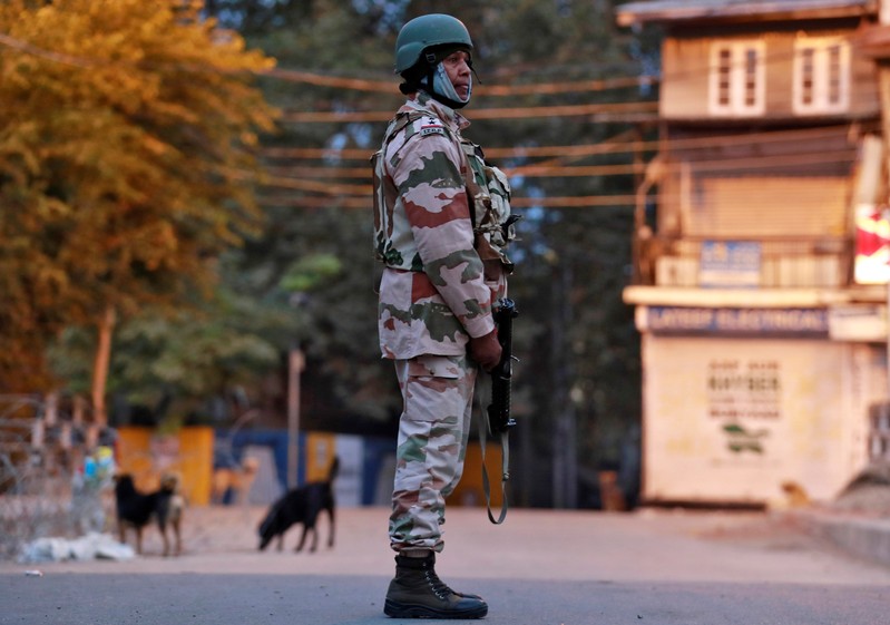 An Indo-Tibetan Border Police officer stands guard on a road in Srinagar