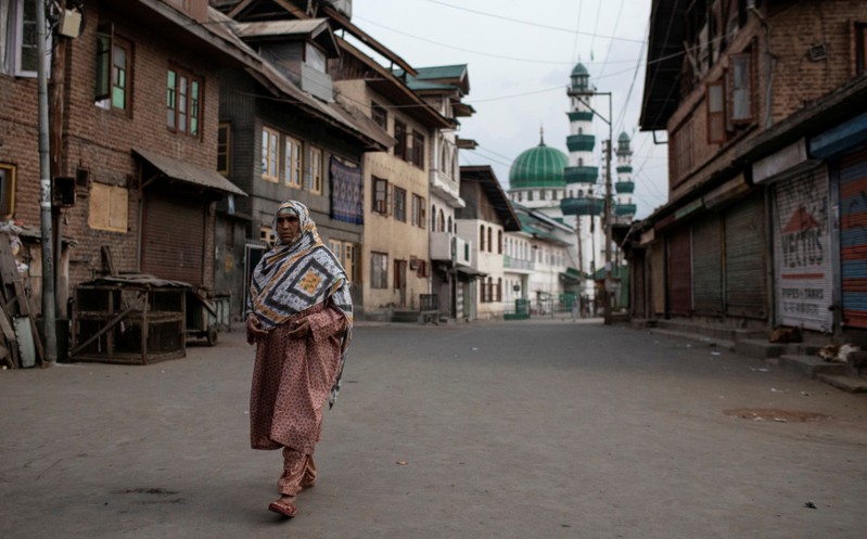 A Kashmiri woman walks through an empty street in Anchar neighbourhood during restrictions in Srinagar