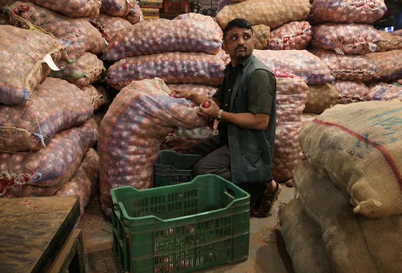 A man sorts onions at a vegetable wholesale market in Mumbai