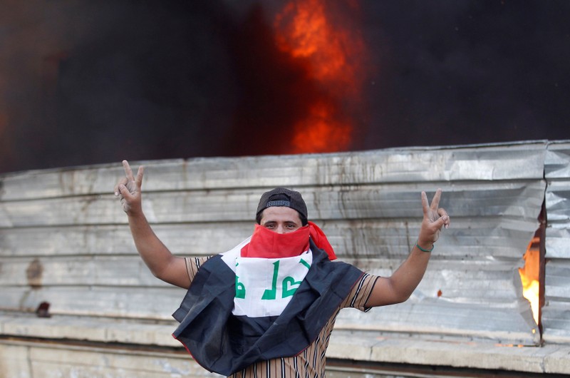 A demonstrator shows the victory signs during a protest against government corruption amid dissatisfaction at lack of jobs and services in Baghdad