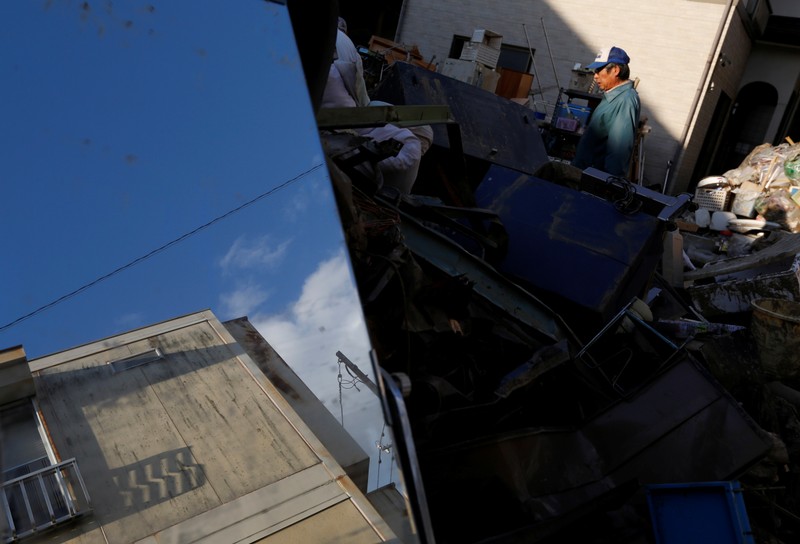 A man is seen near damaged belongings, in the aftermath of Typhoon Hagibis, in Yanagawamachi district, Date City