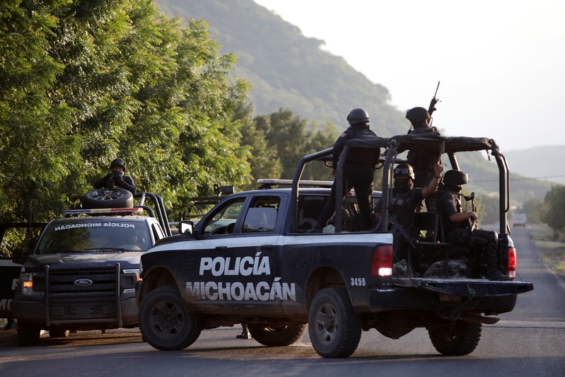 Security forces patrol along a road after police officers were killed during an ambush by suspected cartel hitmen in El Aguaje
