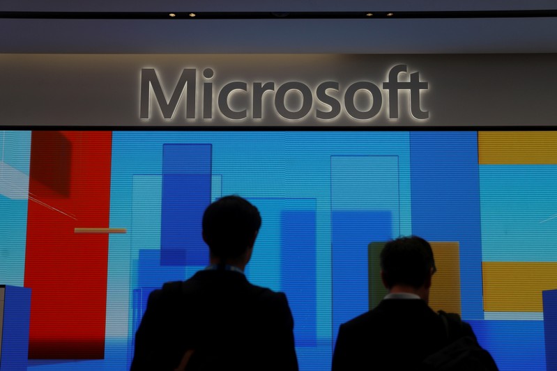 FILE PHOTO: Visitors stand in front of a display screen at Microsoft's new Oxford Circus store ahead of its opening in London